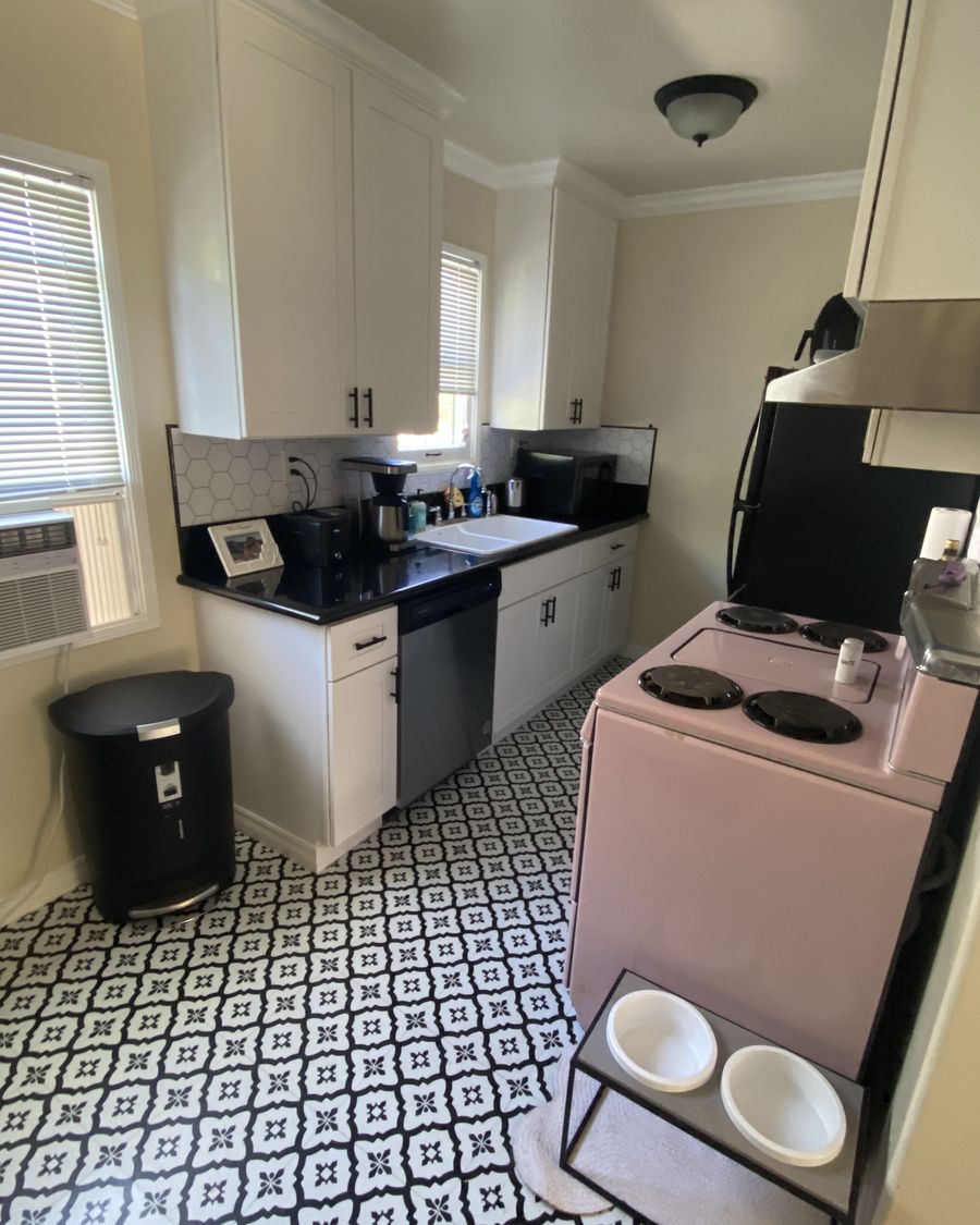 LA apartment kitchen reset between stays: counters cleared, dishes done and put away, bin emptied and relined, patterned tile floor cleaned.
